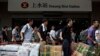 Mainland Chinese visitors line up at Hong Kong's Sheung Shui train station with boxes of instant noodles and packages of diapers to be parallel imported into Shenzhen for resale Aug. 23, 2012.