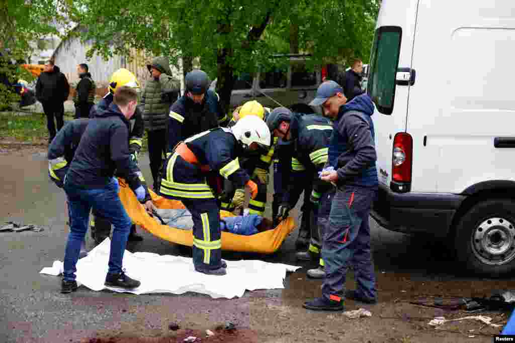 Los rescatistas cargan el cuerpo de una mujer muerta en el lugar de un ataque con misiles rusos, en Chernihiv, Ucrania, el 17 de abril de 2024. REUTERS/Valentyn Ogirenko