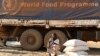 FILE - Seorang perempuan pengungsi duduk di samping truk Program Pangan Dunia (WFP) saat pembagian makanan di Bentiu pada 6 Februari 2023. (Simon MAINA/AFP)