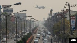 FILE - An airplane flies over a busy road amid high levels of air pollution in Chiang Mai in northern Thailand on March 10, 2023. The long-awaited relaunch of Thailand’s Songkran festival could be overshadowed by the country’s air pollution.