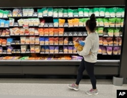 FILE - A shopper looks at cheese offerings at a Target store on Oct. 4, 2023, in Sheridan, Colo.