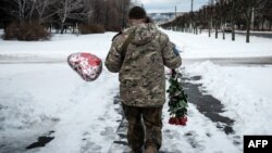 Un militar ucraniano camina con las flores y un globo que compró para el Día de San Valentín en Kramatorsk el 14 de febrero de 2023, en medio de la invasión rusa de Ucrania.