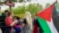 A protester holds a Palestinian flag and the traditional May Day bouquet at the Place de la Republique in Paris.