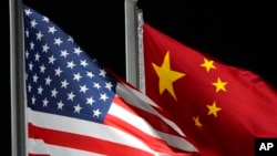 FILE - The American and Chinese flags wave at Genting Snow Park, Feb. 2, 2022, in Zhangjiakou, China. Most U.S. businesses surveyed by the American Chamber of Commerce in China expressed pessimism about the investment climate there going forward.