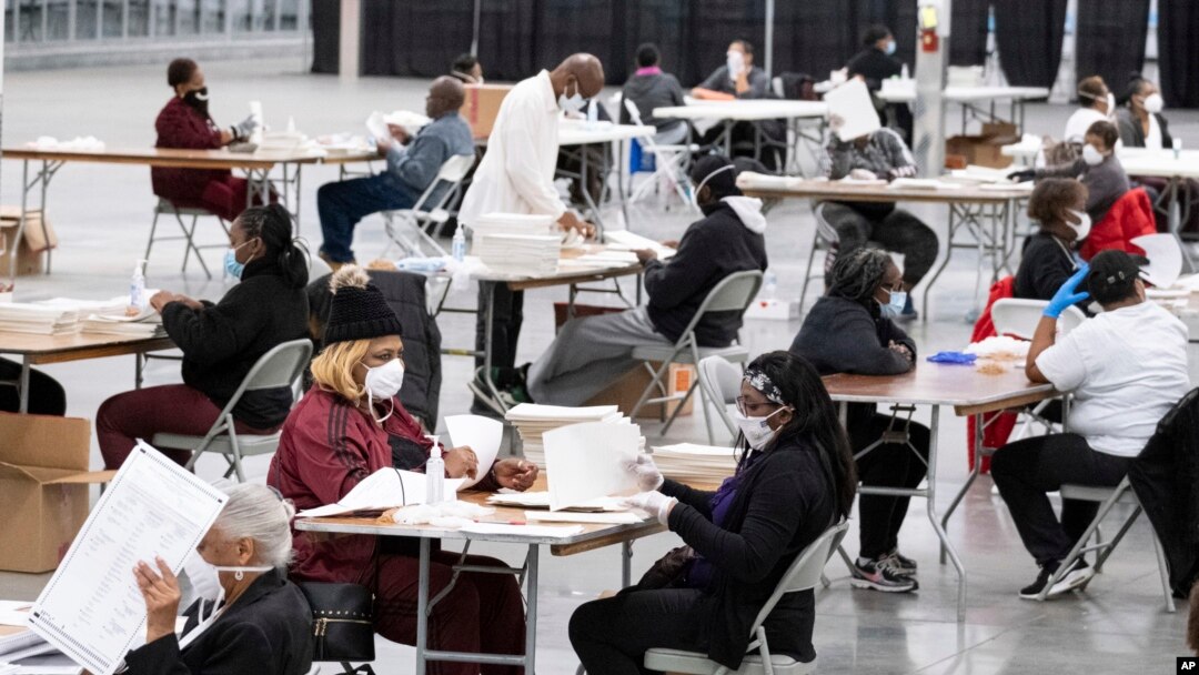 FILE - Workers sort and stack ballots in preparation for scanning as the presidential recount process gets underway, Nov. 24, 2020 in the DeKalb County city of Lithonia, Ga. 