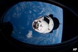 FILE - In this April 24, 2021 file photo made available by NASA, the SpaceX Crew Dragon capsule approaches the International Space Station for docking.