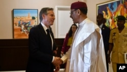 FILE - U.S. Secretary of State Antony Blinken (L) shakes hands with Nigerian President Mohamed Bazoum during a meeting at the presidential palace in Niamey, Niger, March 16.