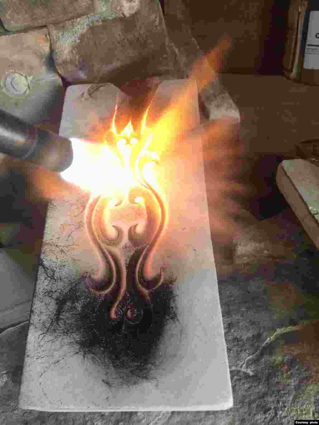 The artist uses a torch to carburize the stone. A coating of carbon ensures that the silver will not stick to the mold.
