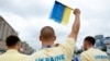 An athlete in the Ukraine delegation holds up a flag ahead of the floating parade on the river Seine during the Paris Olympics opening ceremony in Paris, France, July 26, 2024.