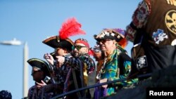 FILE - Members of the Ye Mystic Krewe of Gasparilla give away beaded necklaces to revelers during the annual Gasparilla Pirate Fest in Tampa, Florida, Jan. 29, 2022. 