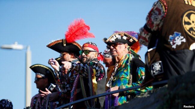 FILE - Members of the Ye Mystic Krewe of Gasparilla give away beaded necklaces to revelers during the annual Gasparilla Pirate Fest in Tampa, Florida, Jan. 29, 2022.