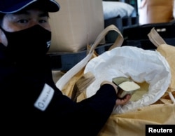 Takemitsu Imazu, President of Biomass Resin Fukushima, shows rice to Reutersin Namie, Fukushima Prefecture, Japan February 28, 2023. (REUTERS/Kim Kyung-Hoon)