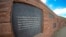 In this view through a fisheye lens, a plaque with a quote from President Bill Clinton is displayed on the wall of healing at the Columbine Memorial, April 17, 2024, in Littleton, Colorado. 