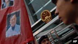 FILE - A protester holds a banner with an image of Hong Kong publisher Yao Wentian during a protest outside the Chinese liaison office in Hong Kong, May 11, 2014. Yao Wentian has been freed after serving a 10-year sentence in a China prison.