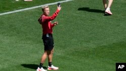 Coach Beverly Priestman of Canada takes photos on the pitch at Geoffroy-Guichard Stadium ahead of the 2024 Summer Olympics, July 23, 2024, in Saint-Etienne, France.