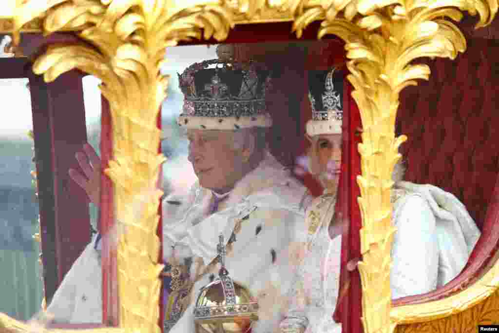 El rey Carlos y la reina Camila de Gran Bretaña viajan desde la Abadía de Westminster en el Gold State Coach, luego de su ceremonia de coronación.&nbsp;