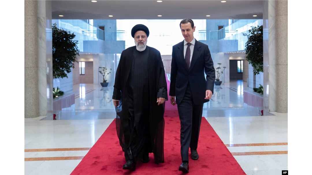 Presiden Suriah Bashar Assad (kanan), berjalan bersama Presiden Iran Ebrahim Raisi di istana kepresidenan di Damaskus, Suriah, Rabu, 3 Mei 2023. (Kepresidenan Suriah via Facebook via AP )