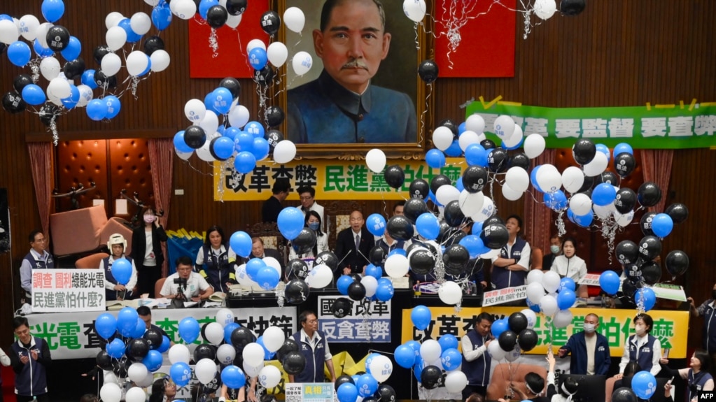 在台湾立法院审议国会改革法案投票时，台湾执政党民进党议员在立法院院长韩国瑜 (中) 的注视下放气球。(2024年5月24日)(photo:VOA)