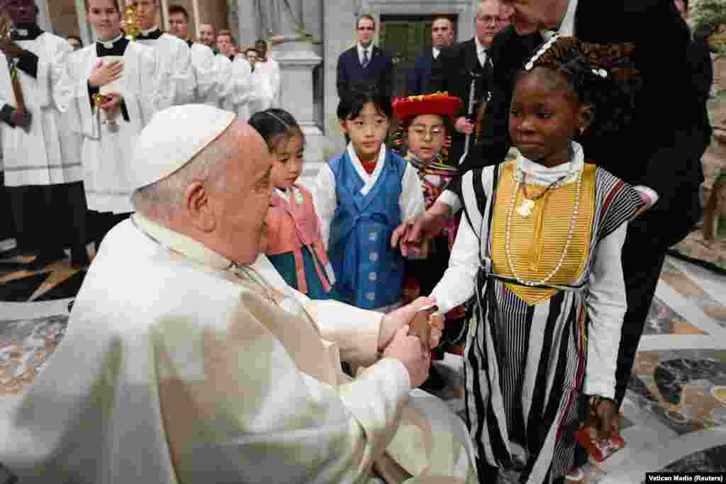 Pope Francis greets children as he celebrates Christmas Eve mass in St. Peter&#39;s Basilica at the Vatican, December 24, 2023.