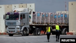 Sebuah truk yang membawa bantuan kemanusiaan menuju Jalur Gaza melaju di area inspeksi di penyeberangan Kerem Shalom di Israel selatan, 14 Maret 2024. (Foto: REUTERS/Carlos Garcia Rawlins)