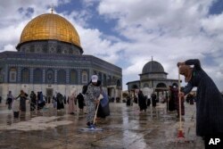Relawan Palestina membersihkan tanah di luar Masjid Dome of Rock di kompleks Masjid al-Aqsa menjelang bulan suci Ramadan, di Kota Tua Yerusalem, 18 Maret 2023. (Foto: AP)