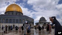 Palestinian volunteers clean the ground outside the Dome of Rock Mosque at the al-Aqsa Mosque compound ahead of the Muslims holy month of Ramadan, in Jerusalem's Old City, March 18, 2023.