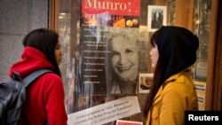 FILE - Customers look at a window display congratulating Canadian author Alice Munro at bookstore Munro's Books after she won the Nobel Prize for Literature in Victoria, British Columbia, Oct. 10, 2013. The writer has died at the age of 92, her publisher said this week.