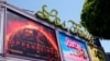 Poster film "Barbie" dan "Oppenheimer" terpasang di bioskop Los Feliz di Los angeles, pada 28 Juli 2023. (Foto: AP/Chris Pizzello)