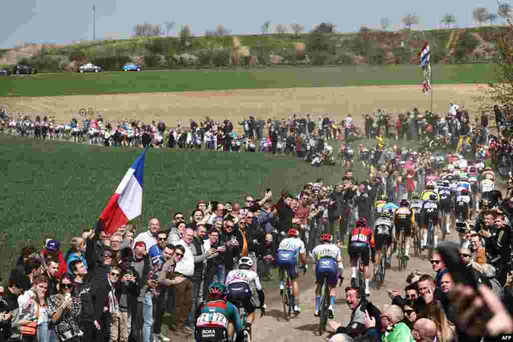 The pack of riders cycles over a cobblestone sector near Troisvilles, northern France, during the 120th edition of the Paris-Roubaix one-day classic cycling race, between Compiegne and Roubaix, northern France.