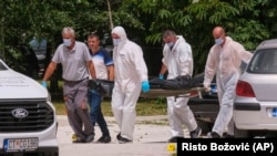 Policija odnosi telo poginule osobe sa mesta eksplozije na Cetinju, 20. jun 2024. (AP Photo/Risto Bozovic)
