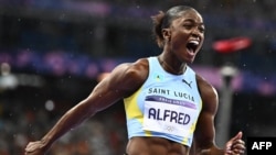 Saint Lucia's Julien Alfred celebrates winning the women's 100m final of the athletics event at the Paris 2024 Olympic Games at Stade de France in Saint-Denis, north of Paris, Aug. 3, 2024. 