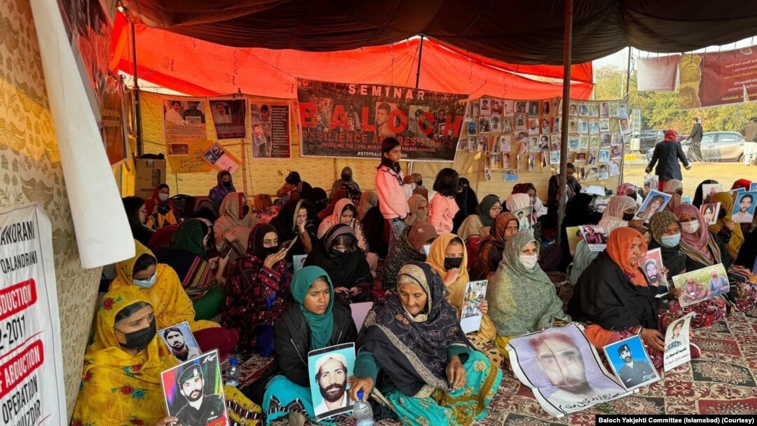 
د کراچۍ په مظاهره کې د لفټ ډيموکريټک فرنټ تنظيم غړو په اسلام اباد کې د بلوڅ یکجهتي کونسل پرلت سره د يوالي اظهار هم وکړو. په دې تصویر کې د بلوچ یکجهتي کونسل فعالان لیدل کېږي چې په اسلام اباد کې د خلکو د بې درکیو په ضد په پرلت ناست دي

