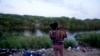 Honduran migrant Maria Karina Balladares holds her son on the Mexican side of the Rio Grande where other migrants have crossed over into the U.S. to turn themselves to immigration authorities, in Matamoros, Mexico, May 11, 2023.