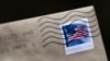 FILE - A U.S. postage stamp is seen on an envelope in Washington, D.C., May 28, 2021. 