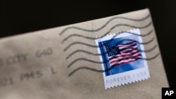FILE - A U.S. postage stamp is seen on an envelope in Washington, D.C., May 28, 2021. 