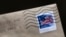 FILE - A U.S. postage stamp is seen on an envelope in Washington, D.C., May 28, 2021. 