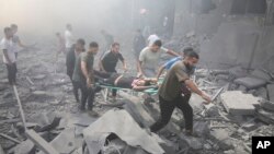 Palestinians evacuate wounded people after an Israeli airstrike in Rafah refugee camp, southern Gaza Strip, Oct. 12, 2023. 