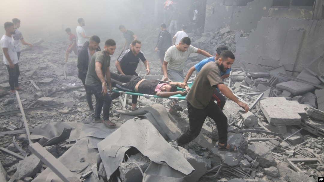 Palestinians evacuate wounded people after an Israeli airstrike in Rafah refugee camp, southern Gaza Strip, Oct. 12, 2023. 
