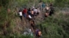 大批来自中美洲的移民渡过美墨边境的格兰德河进入美国德克萨斯州，向美国边境巡逻人员报到。（2023年5月10日）