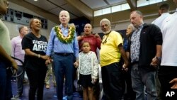 President Joe Biden poses for a photo as he meets with community members impacted by the Maui wildfires at Lahaina Civic Center, Aug. 21, 2023, in Lahaina, Hawaii. 