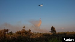 FILE - Helikopter dari Badan Nasional Penanggulangan Bencana (BNPB) menjatuhkan air untuk memadamkan kebakaran lahan di Kabupaten Muara Pawan, Ketapan, Provinsi Kalimantan Barat, 30 Juli 2019. (Antara Foto/Heribertus/ via REUTERS)