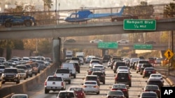 FILE - A movie-prop helicopter parked on a bridge causes traffic to slow on the Hollywood Freeway below, in Los Angeles, Dec. 12, 2018. California could soon deploy generative artificial intelligence tools to help reduce traffic jams.