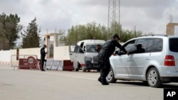 A police officer checks a car near Ghriba synagogue in Djerba, Tunisia, May 10, 2023. 