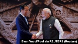 Perdana Menteri India Narendra Modi berjabat tangan dengan Presiden Joko Widodo setibanya di acara KTT G20 di Bharat Mandapam, New Delhi, India, Sabtu, 9 September 2023. (Foto: Evan Vucci/Pool via REUTERS)