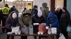 Elderly people wait to receive bread and hot food products from a humanitarian organization in the Saltivka neighborhood of Kharkiv, Ukraine, an area badly damaged by Russian shelling where most buildings are without electricity or water, Feb. 17, 2023.