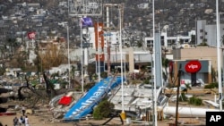 Residents walk past debris in the aftermath of Hurricane Otis in Acapulco, Mexico, Oct. 27, 2023.