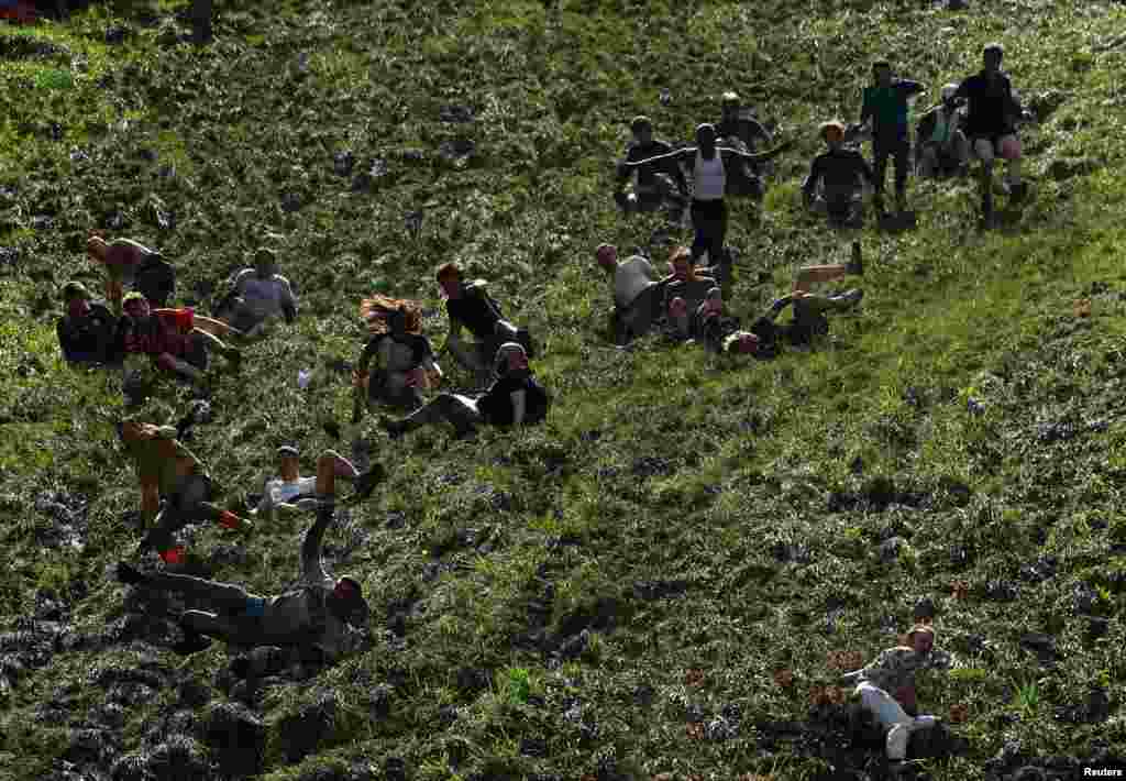 People compete in the annual Cooper&#39;s Hill Cheese Rolling competition in Brockworth, Britain.