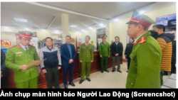 Các nhân viên đăng kiểm tại một trung tâm đăng kiểm ở tỉnh Nghệ An đang nghe công an đọc lệnh bắt (Ảnh chụp màn hình báo Người Lao Động)