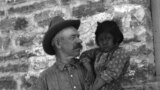 This 1917 photo shows John A. Keirn and an unidentified Hopi child standing outside of the Moencopi Day School on the Hopi Reservation in Arizona. Courtesy of USU Special Collections, Merrill-Cazier Library.