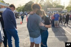 Dos adolescentes se abrazan en una vigilia de oración el domingo 16 de abril de 2023, afuera de la Primera Iglesia Bautista en Dadeville, Alabama. Varias personas murieron y más de dos docenas resultaron heridas en un tiroteo en una fiesta de cumpleaños de adolescentes en la ciudad el sábado 15 de abril. (Foto AP/Jeff Amy)